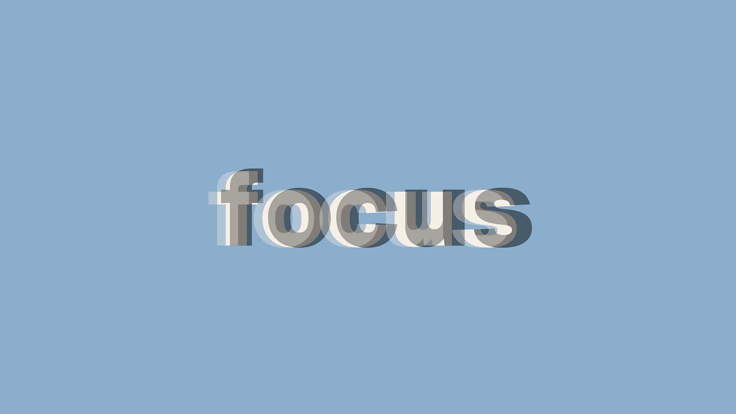 The word 'focus' repeated in overlapping, staggered layers of cream and gray text on a light blue background, creating a blurred, out-of-focus visual effect.