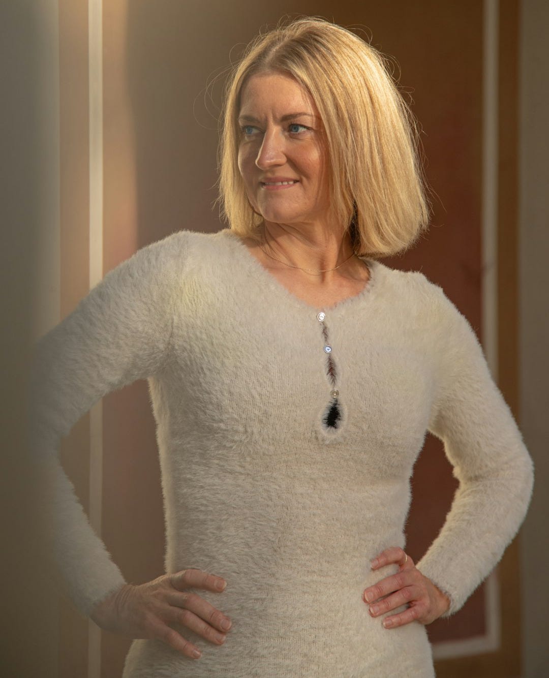 A woman standing in front of a mirror with her hands on her hips