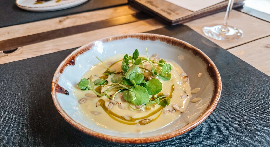 A plate of cheese ravioli in a stone bowl on top of a black tablemat