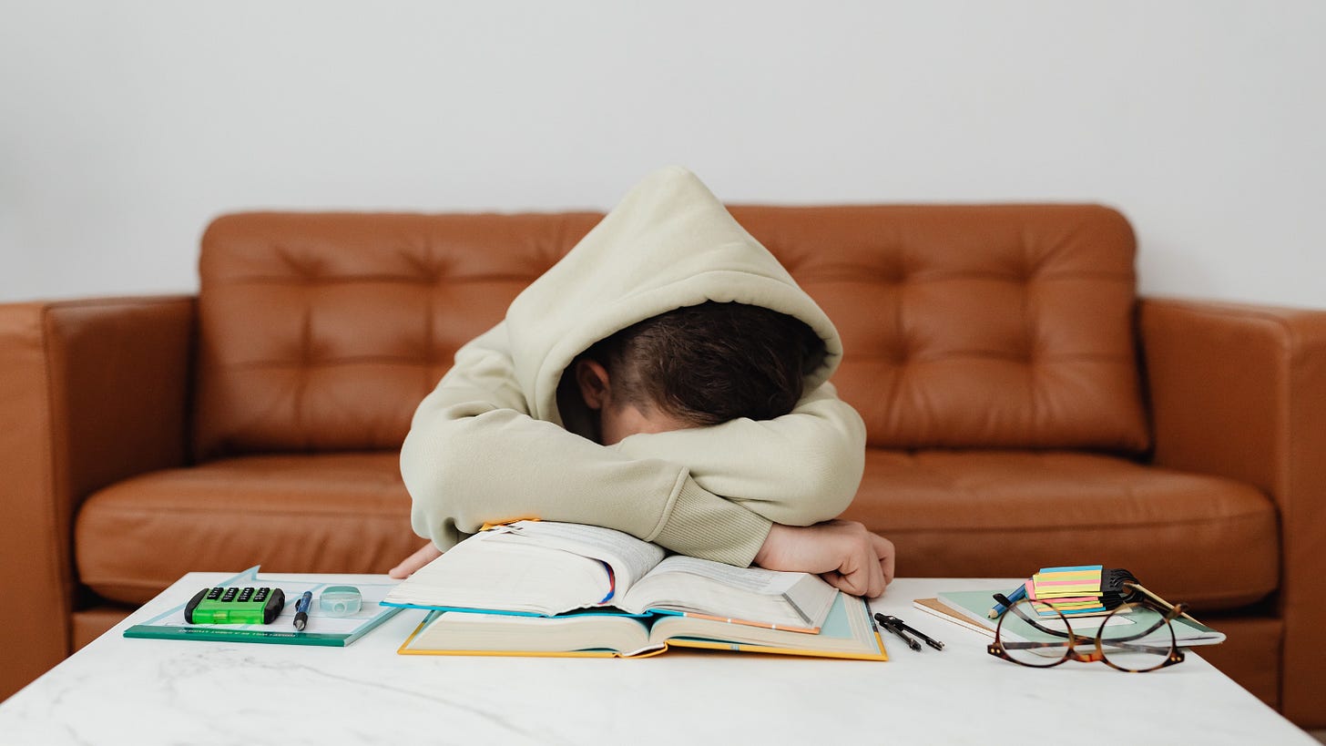 Discouraged boy with his head down on a textbook