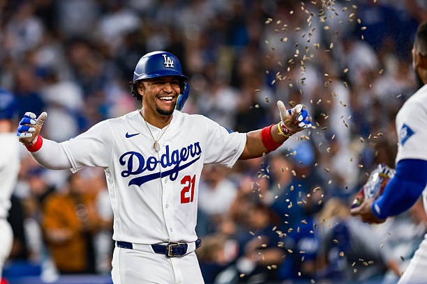 Santiago Espinal of the Los Angeles Dodgers celebrates with teammate Teoscar Hernández after hitting a home run during the game between the San...
