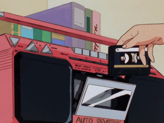 This may contain: a hand is holding an electronic device in front of a machine with stacks of boxes on top