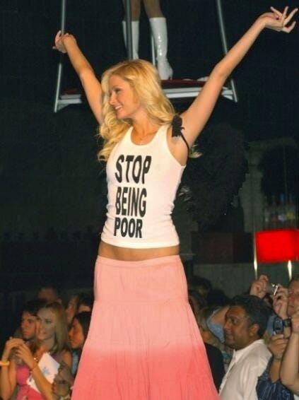 This may contain: a woman standing on top of a stage with her arms in the air and hands up