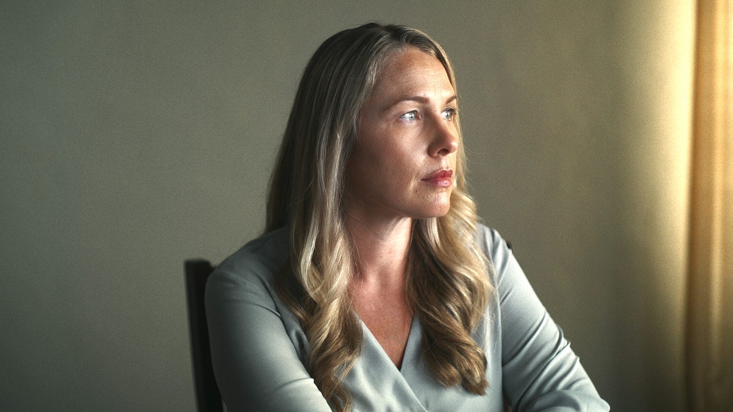 Denise Huskins in American Nightmare sitting looking toward the window