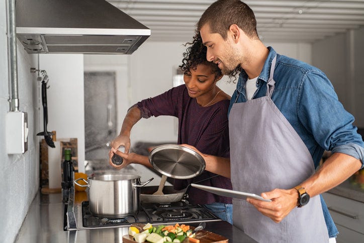Couple cooking together in a kitchen.