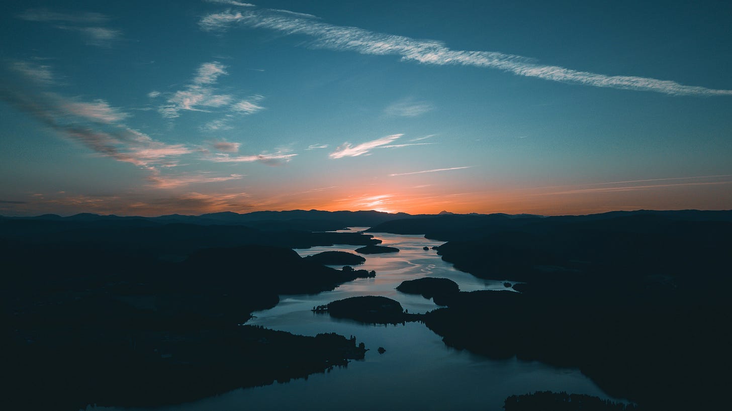 Orange and blue sky over river at dusk