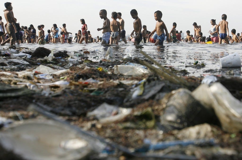 People paddle in the waters of Manila Bay amid garbage during Easter Sunday in Manila April 24, 2011. Photo by Cheryl Ravelo/Reuters