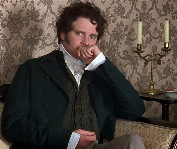 This may contain: a man sitting in a chair with his hand on his mouth