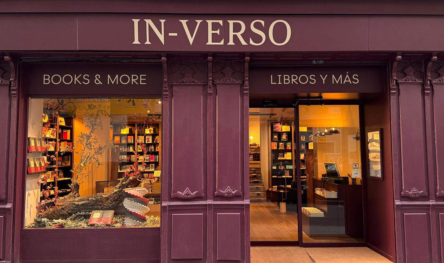 Vista de la fachada de una librería llamada IN-VERSO, con letreros en inglés y español, y exhibición de libros en la ventana Vista de la fachada de una librería llamada IN-VERSO, con letreros en inglés y español, y exhibición de libros en la ventana