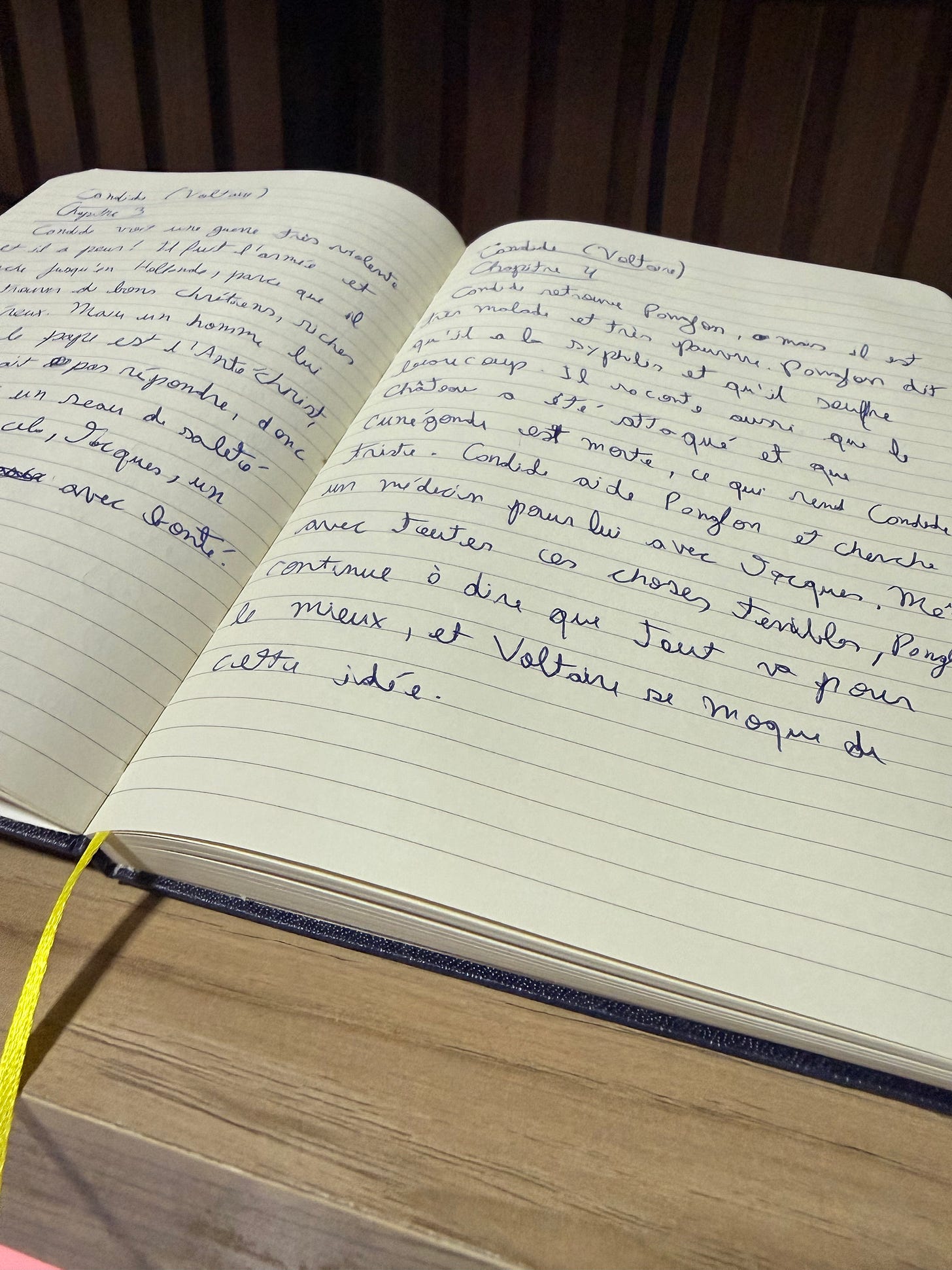 Mesa de madeira, caderno com marcador amarelo, páginas brancas com anotações sobre o livro Cândido de Voltaire, escritas à mão em francês. Mesa de madeira, caderno com marcador amarelo, páginas brancas com anotações sobre o livro Cândido de Voltaire, escritas à mão em francês.