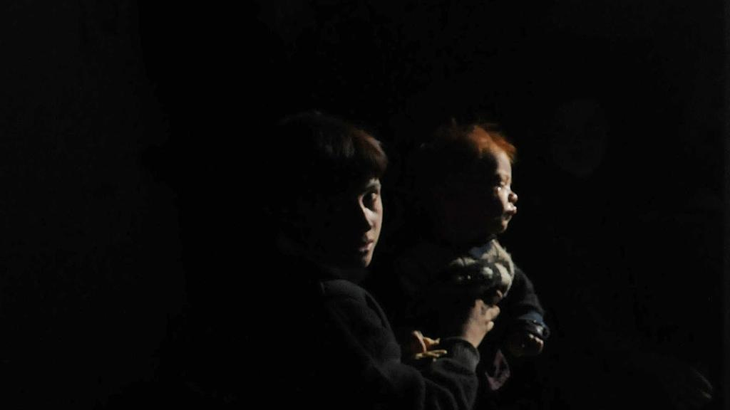An internally displaced girl holds a baby after her family left their village in the Achin district of Afghanistan. Mohammad Anwar Danishyar / AP Photo