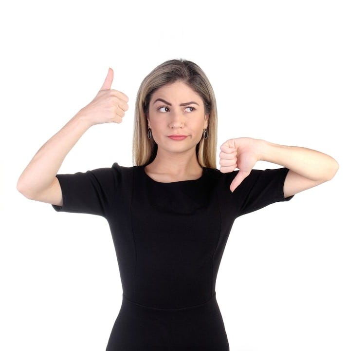 a woman in a black shirt is pointing at buttons a woman in a black shirt is pointing at buttons