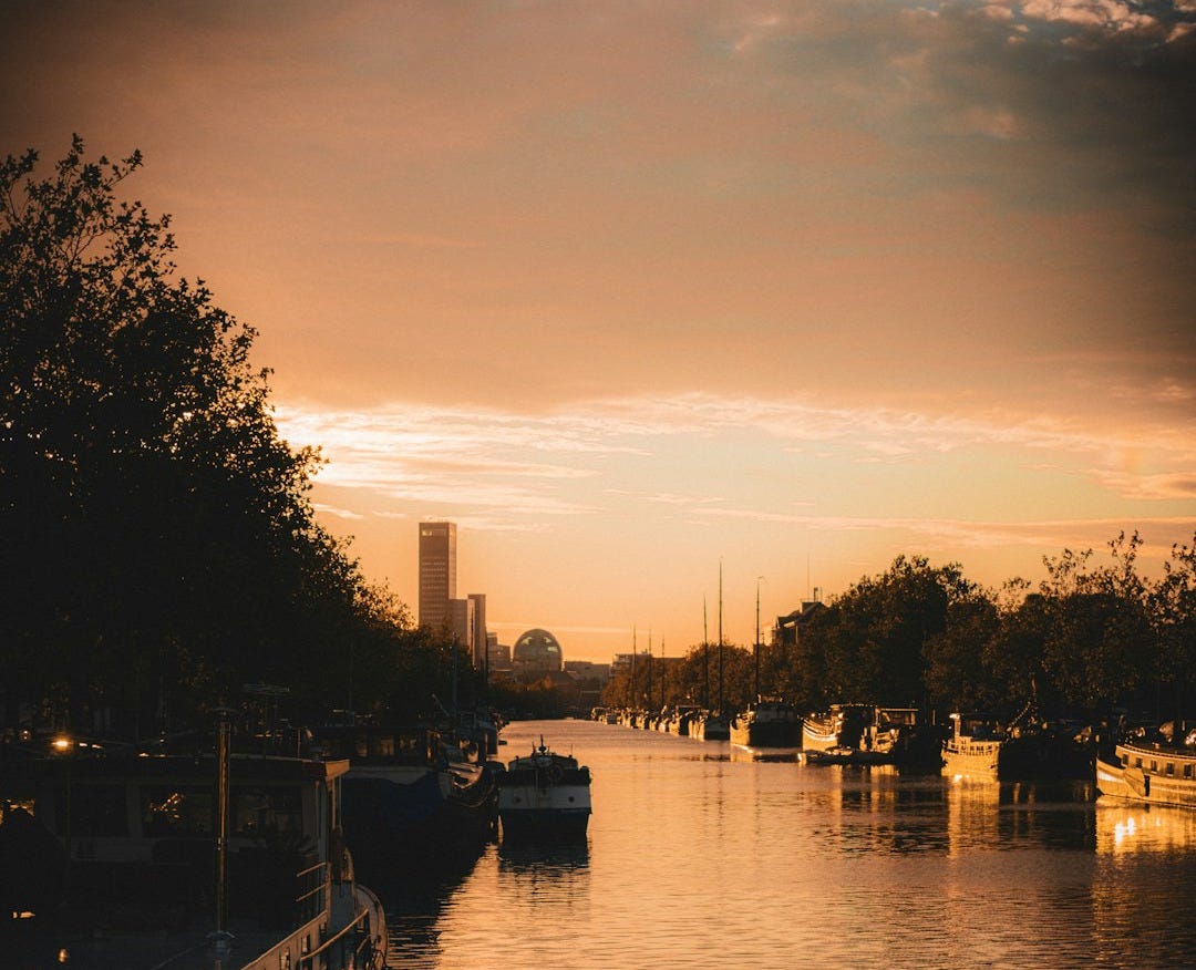 A river filled with lots of boats under a cloudy sky