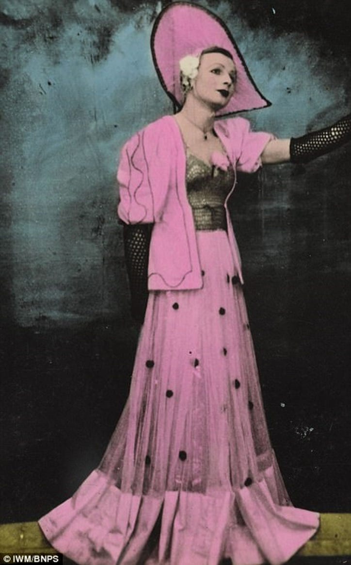 Don ‘Pinky Smith’ dressed head to foot in pink — Gainsborough hat, fishnet evening gloves, fitted bodice and long, flared skirt. He has a white flower in his hair, too