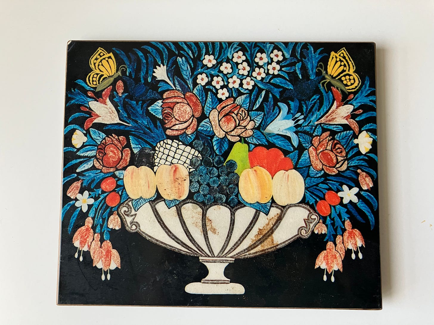 multicolored flowers overflowing a wide white bowl