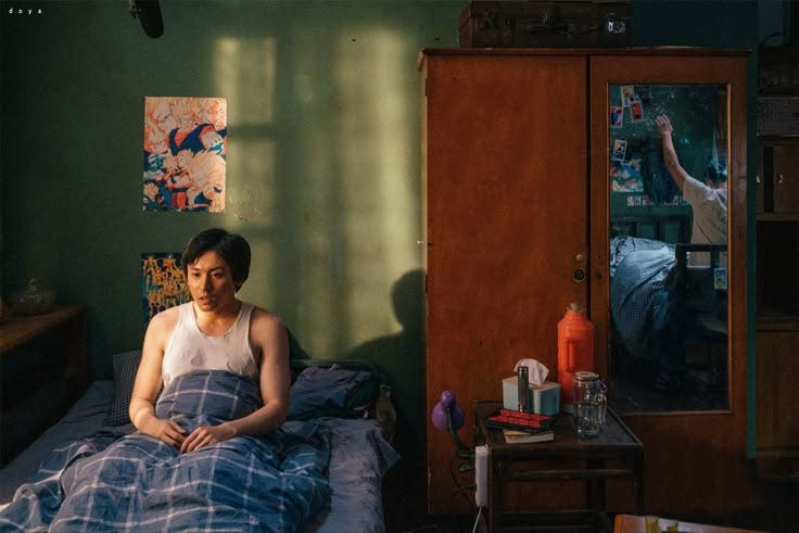 This may contain: a woman sitting on top of a bed in a room with green walls and furniture