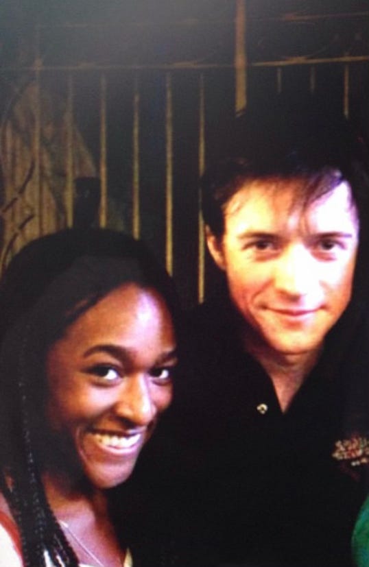 Left - Pippin Stagedoor. Alexa and Matthew James Thomas. You can only see Alexa’s face and a little bit of her hair which is small box braids hanging down her back. She is grinning widely. Matthew James Thomas is grinning as well. He wears a dark polo that appears black in this photo. There is a wisp of hair covering his forehead. They appear to be standing in front of a set of golden bars, perhaps a gate. Right - Hu Kitchen in downtown New York. Patina Miller and Alexa stand smiling next to eachother in front of a food buffet type station. Patina is crouching down a bit, but is still taller than Alexa. She wears a black tanktop and black leggings with a white design that resembles polka dos. She is also wearing a black cap. Alexa is wearing a gray tank top with a hot pink sports bra underneath. She is also wearing a long chain necklace, the front of which is covered by big black sunglasses hanging from her shirt. She is wearing a purple long champ tote bag with brown handles on her shoulder. Patina has an a watch that looks like an Apple Watch on her wrist.