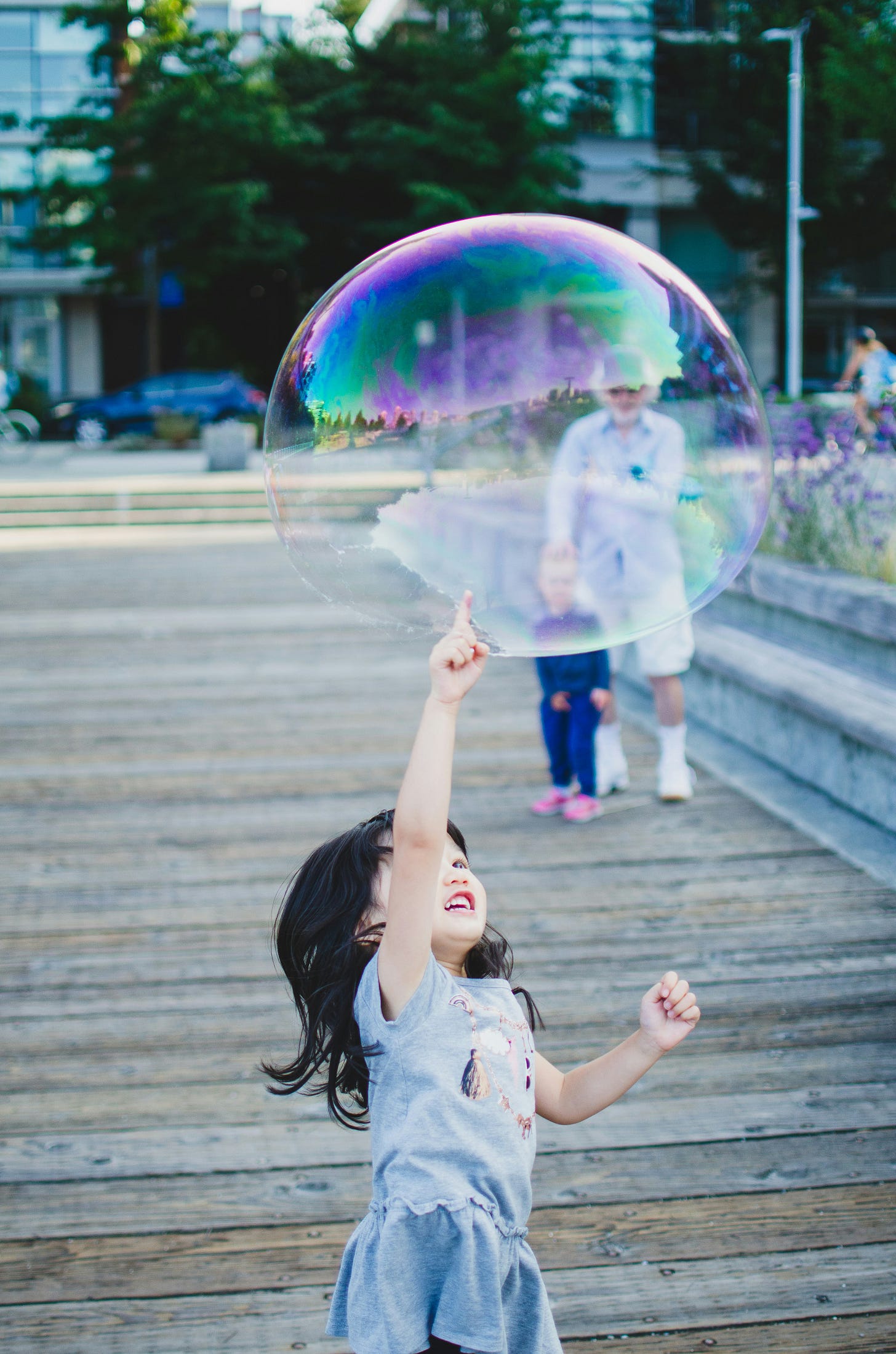 Child poking a large bubble Child poking a large bubble