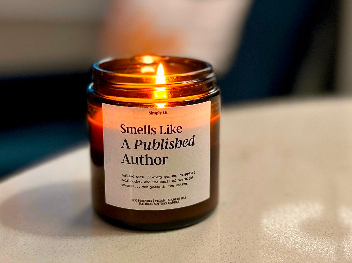 Candle burning in an amber jar with a label that reads: Smells like a published author. Candle burning in an amber jar with a label that reads: Smells like a published author.
