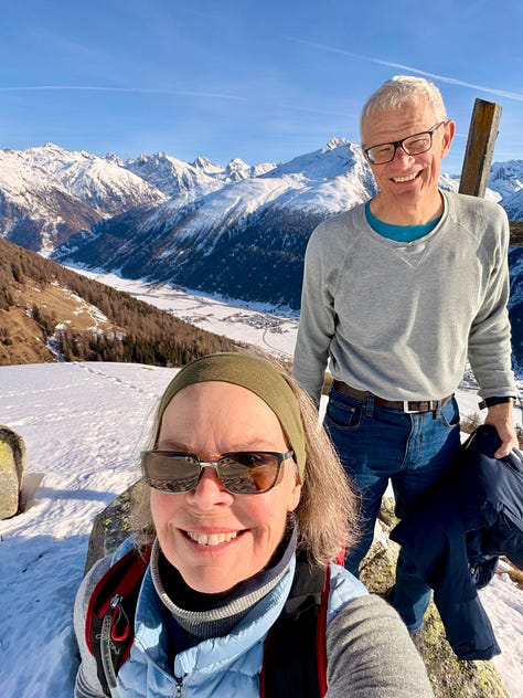 Left image, an elderly couple in a winter, alpine setting, high above a snow-covered valley floor smile for a selfie. Behind them, snow-capped mountain peaks; middle image, blackbirds riding the thermal above the Upper-Rhone Valley.; middle image, the top-right portion of a large wooden cross in a winter alpine setting. The cross perches over a snow-covered valley and mountain peaks opposite. A swarm of blackbirds ride a thermal.; right image, A snow-covered alpine valley floor from an elevate position. A metatrons cube has been raked into the snow using cross-hatching.