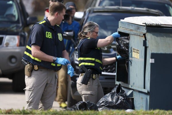 Agentes del Buró de Investigaciones de Georgia registran un contenedor de basura al otro lado de la calle de los apartamentos Cielo Azulak, el viernes 23 de febrero de 2024, en Athens, Georgia. (Jason Getz/Atlanta Journal-Constitution via AP)