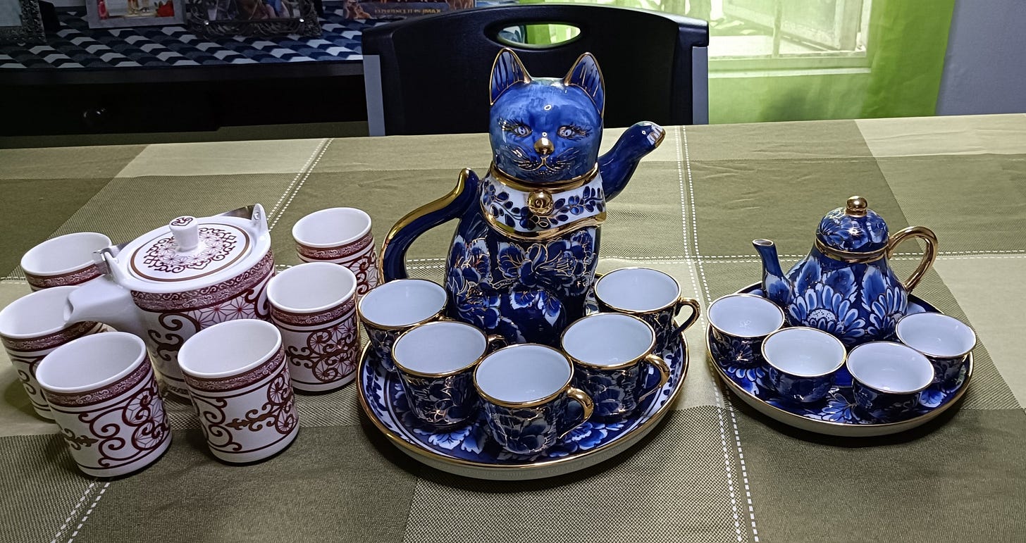 Three tea sets with different styles - oriental (left), cat (center), blue floral (right)