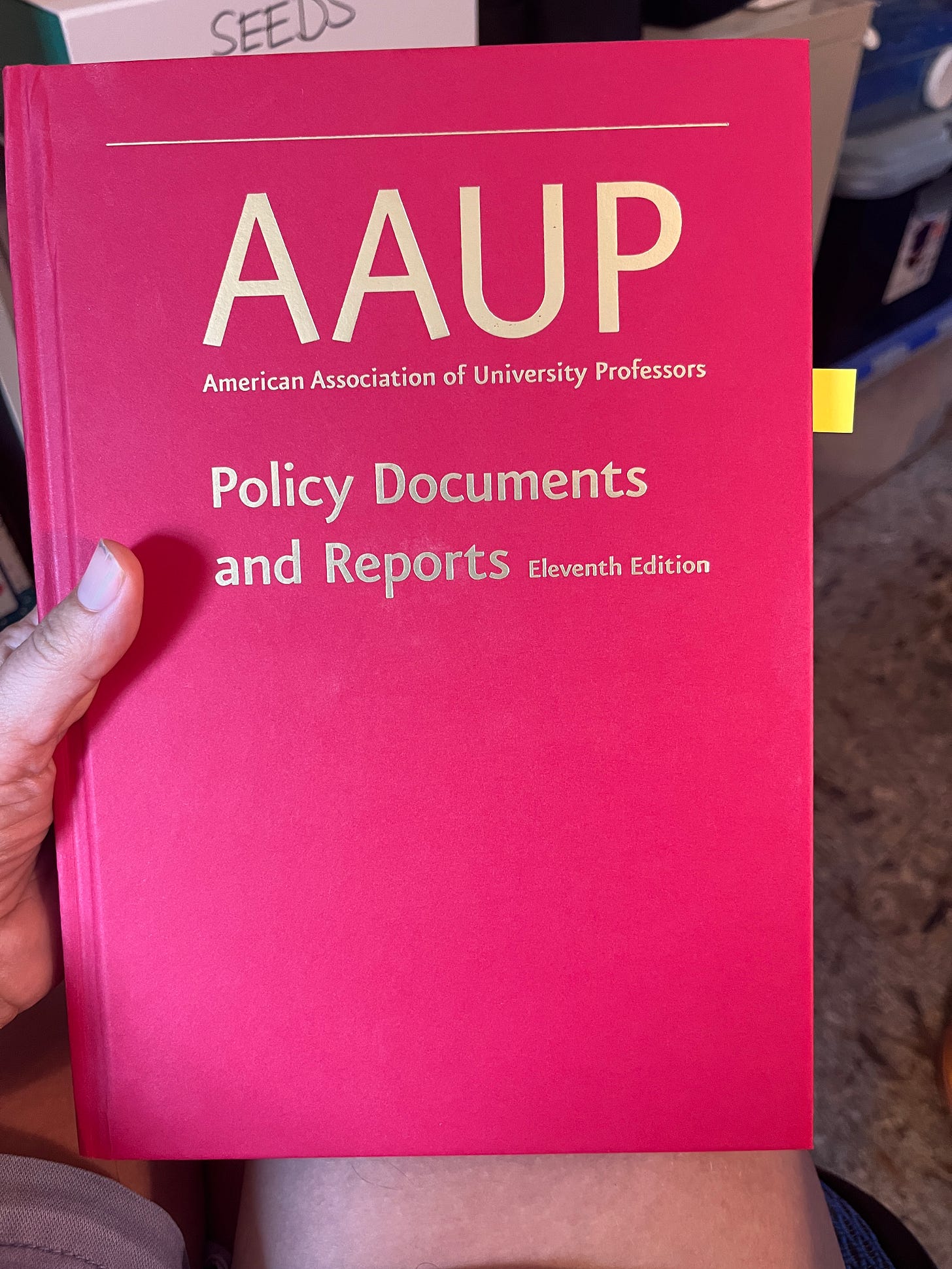 A red hardcover book with gold lettering that reads AAUP: American Association of University Professors, Policy Documents and Reports, Eleventh Edition