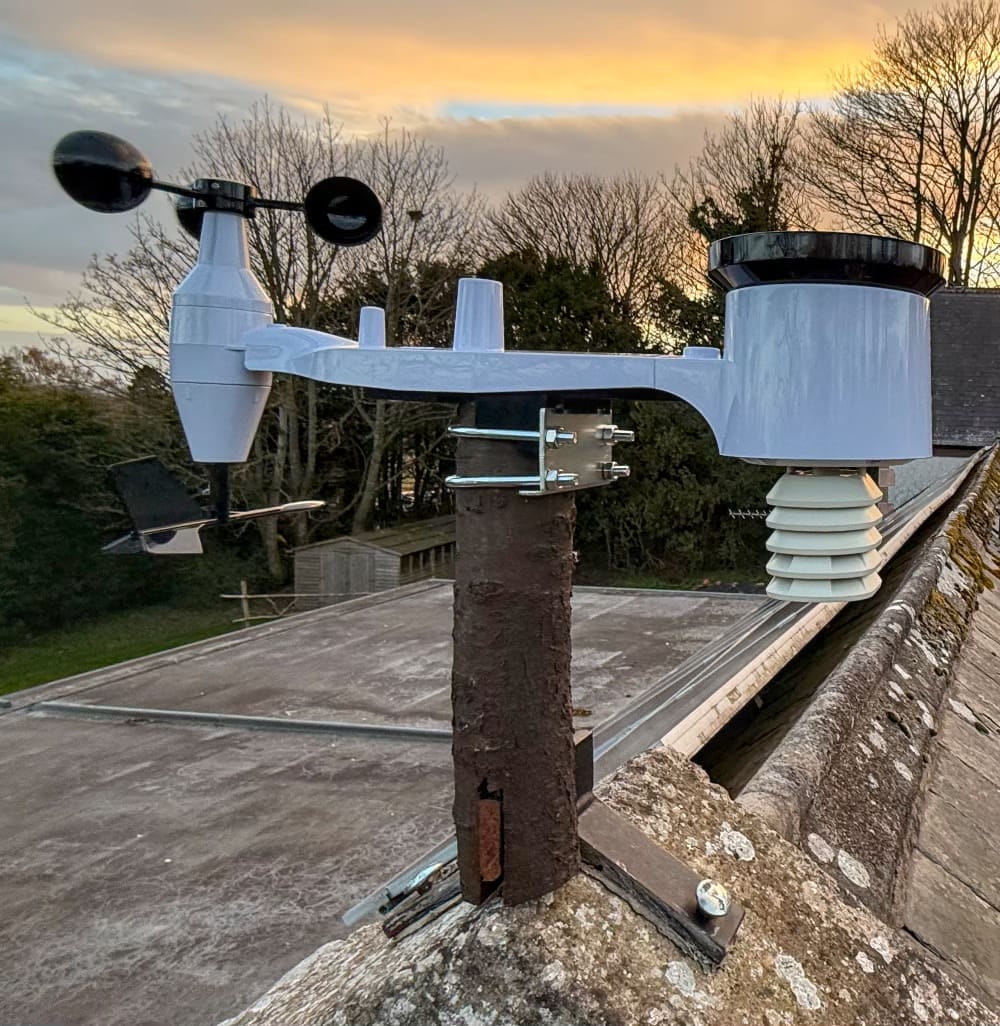 A weather station on the end of a roof.