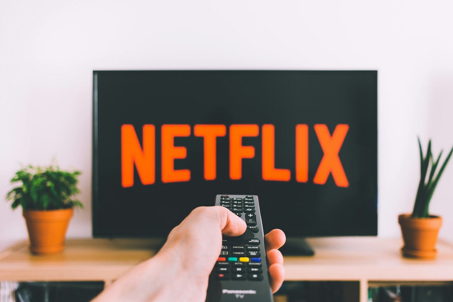 person holding remote pointing at TV person holding remote pointing at TV