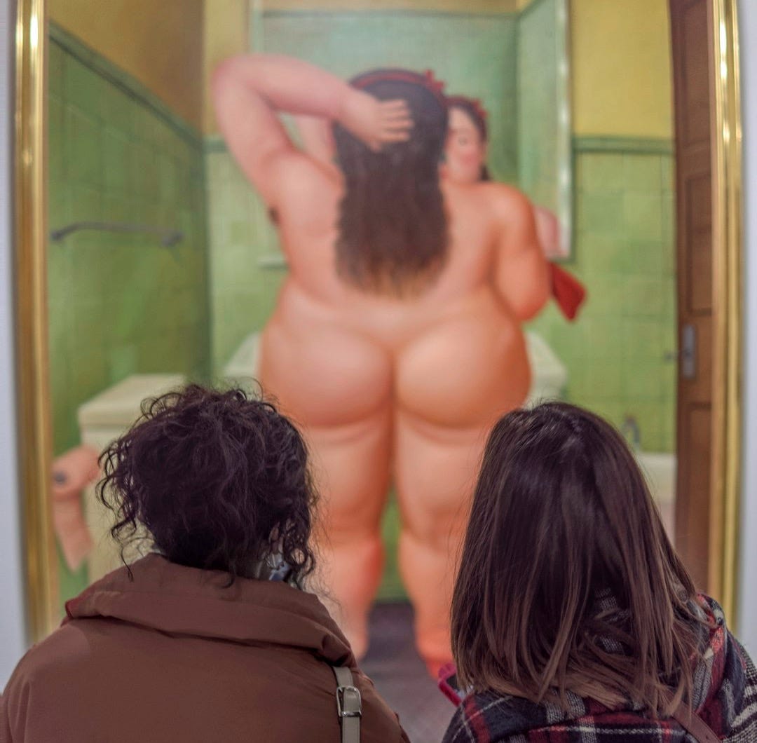 a couple of people that are looking at a painting a couple of people that are looking at a painting