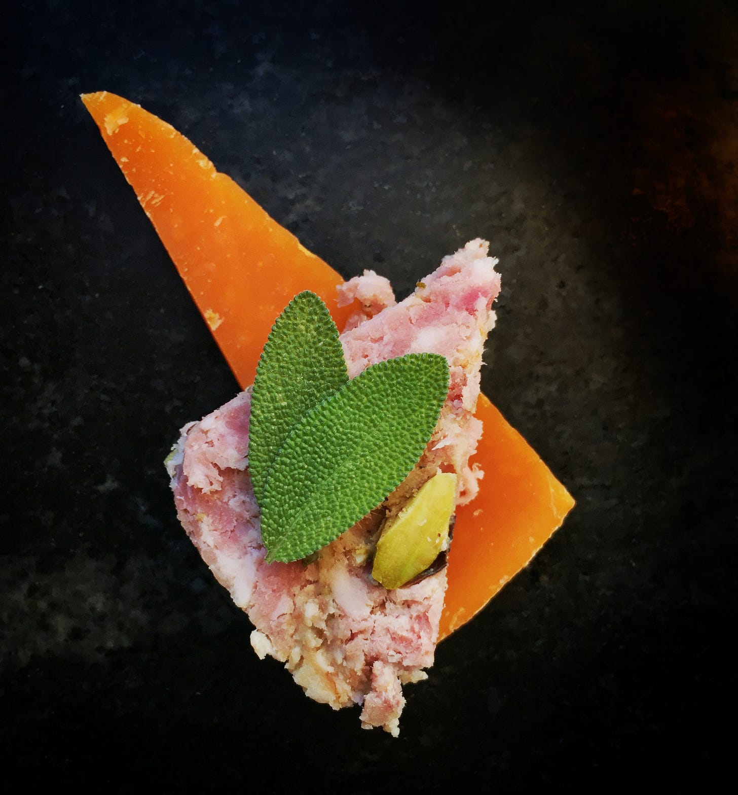 Pistachio pâté on a slice of Mimolette with a little fresh sage