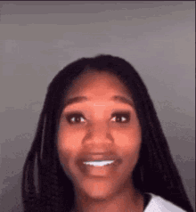 a woman with braids is smiling for the camera . a woman with braids is smiling for the camera .