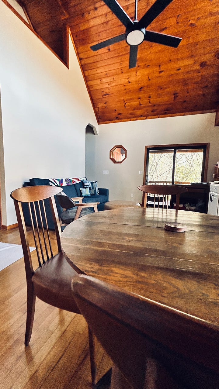 Two photos of chairs at an antique table, in the WoolTribe Studio cabin.