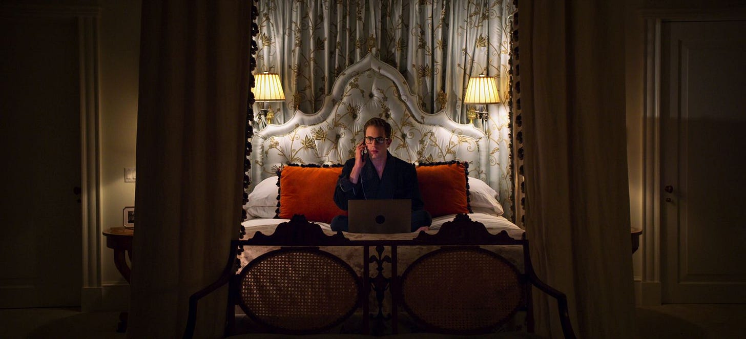 a boy sitting in a floral canopied bed