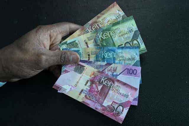 A hand holding Kenyan currency notes of 1,000, 500, 200, 100 and 50 A hand holding Kenyan currency notes of 1,000, 500, 200, 100 and 50