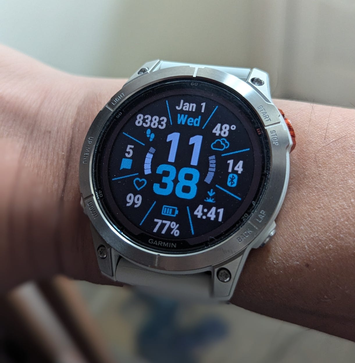 Garmin smart watch worn on wrist. Time is 11:30 on Jan 1, 2025