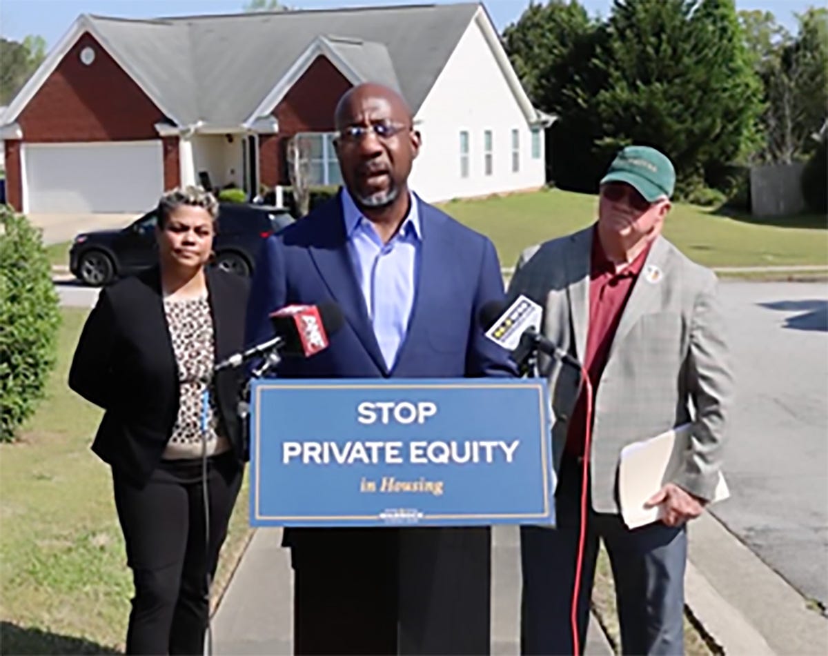 Georgia Senator Raphael Warnock and supporters in front of a "Stop Private Equity in Housing" sign Georgia Senator Raphael Warnock and supporters in front of a "Stop Private Equity in Housing" sign