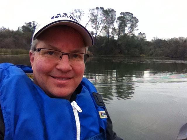 Life jackets, paddler wearing life jacket, backpack, water bottles, picnic basket, and outdoor shoes