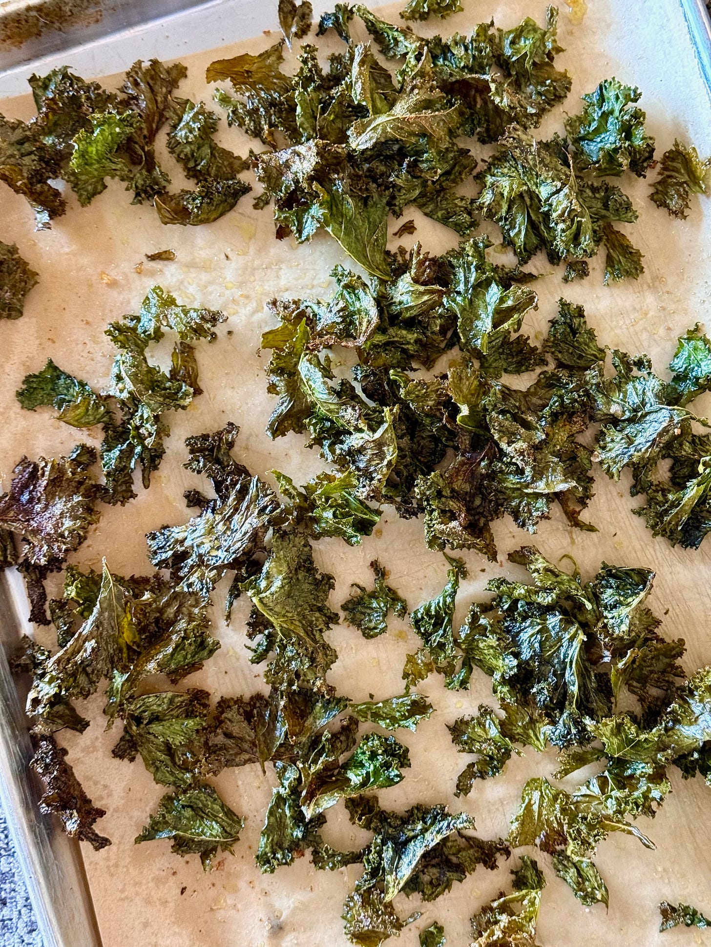 a sheet pan of baked kale chips. studio delicious.com