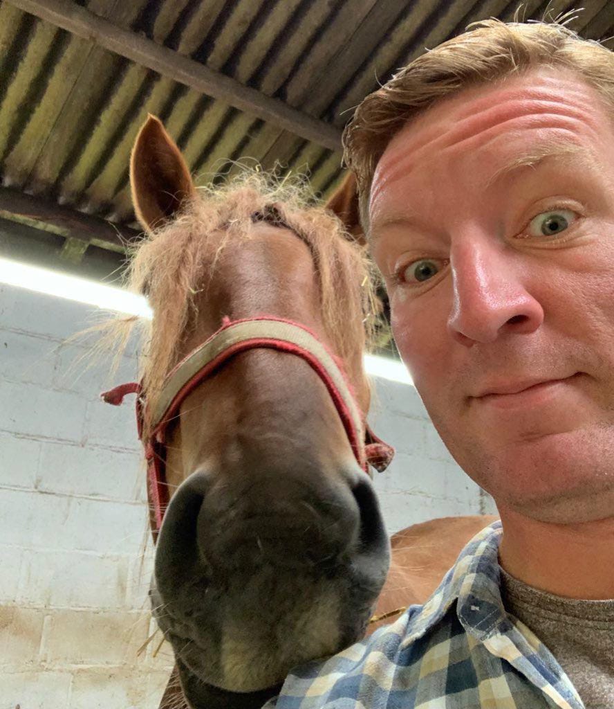 A surprised looking Ben, with a Suffolk Punch horse behind him.