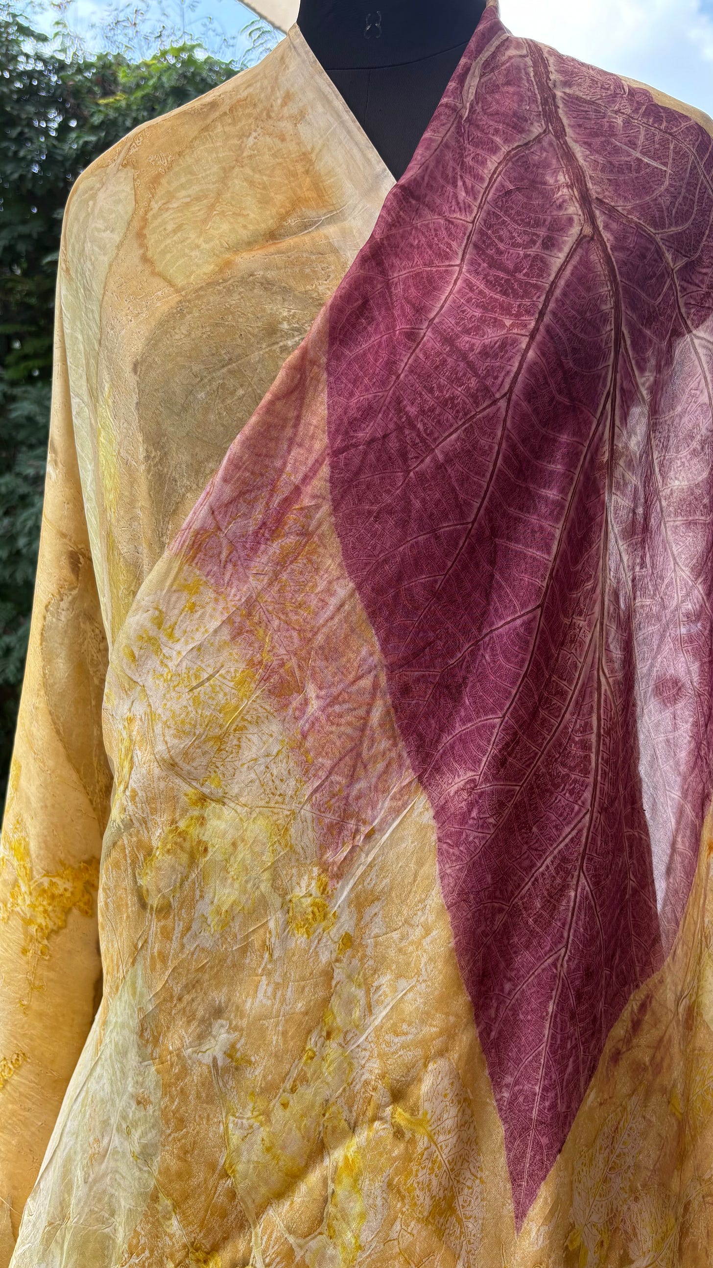 Mannequin draped in an eco-printed textile in warm yellow tones with a mauve panel.