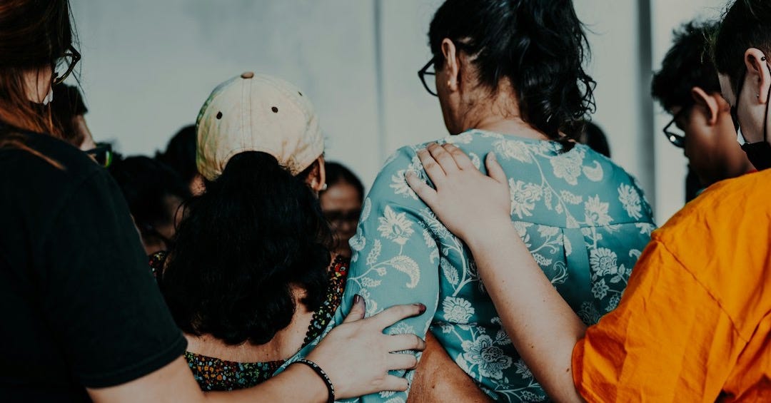 a group of people standing around each other a group of people standing around each other