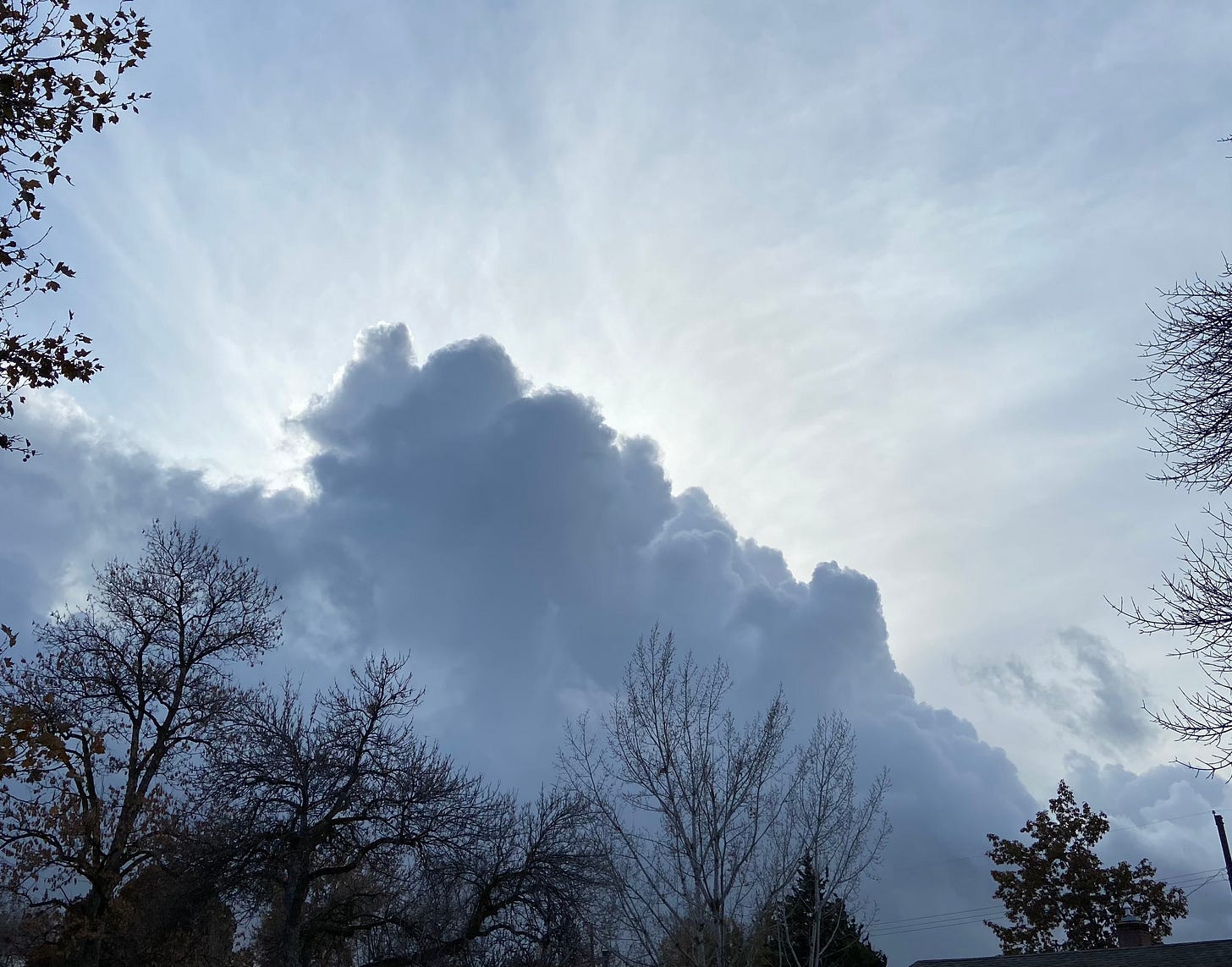 Bright white sunbeams from behind a blue-grey cloud