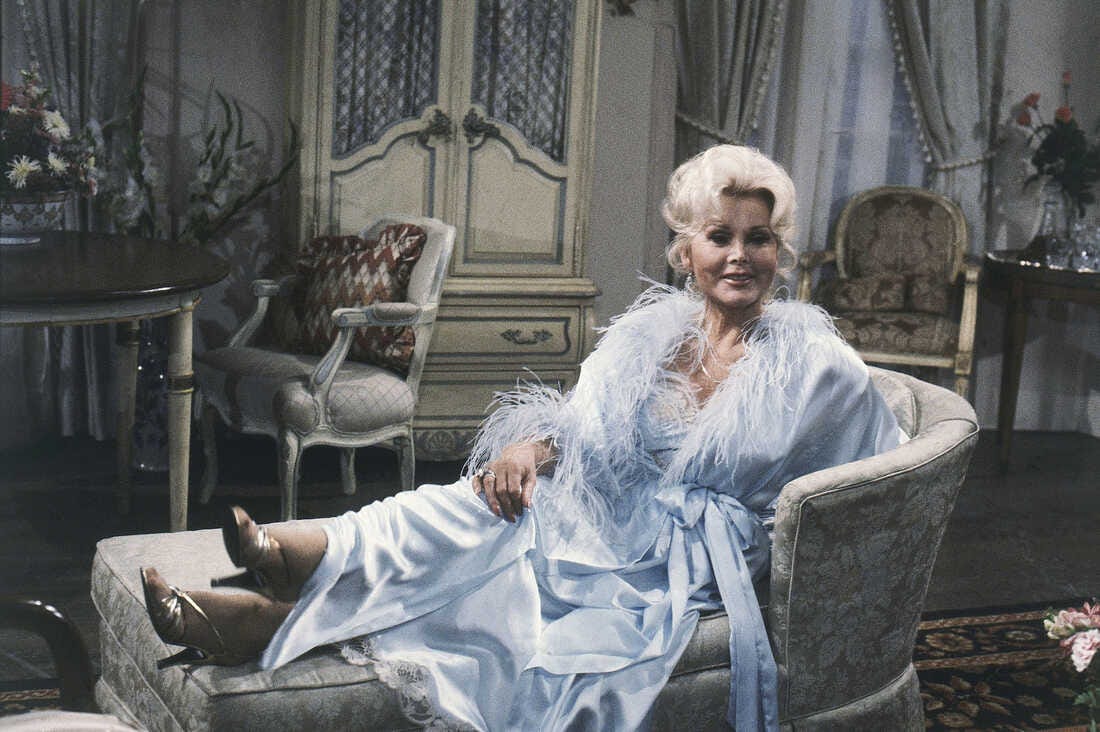 Woman on a chaise lounge in a blue negligee with feathers
