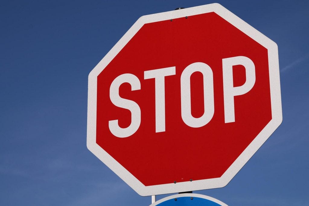 Red stop sign on blue sky background