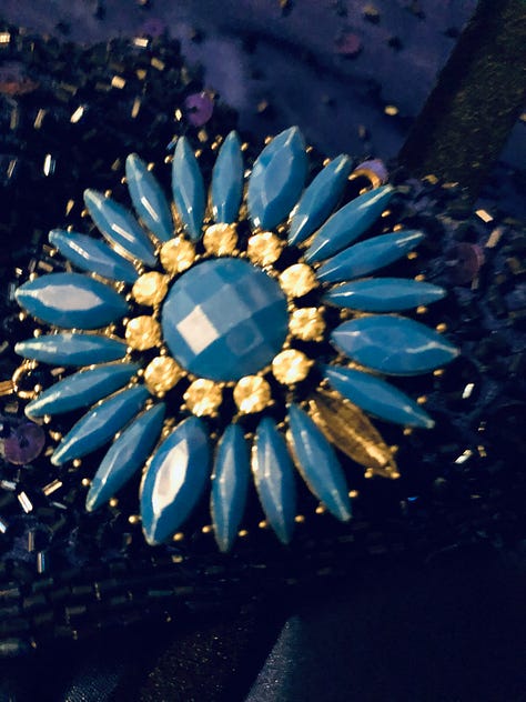 Mended coin belt, re-sparked cup, and a blue daisy necklace with a missing petal