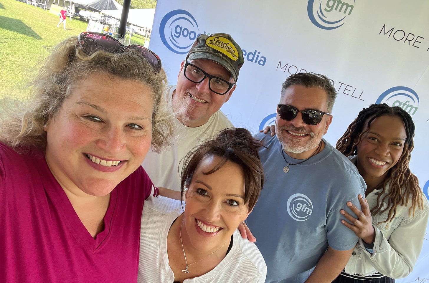 Jamie stands next to a white woman, a white man in a cap, a Native American man, and a black woman with the Good Faith Media logo in the background