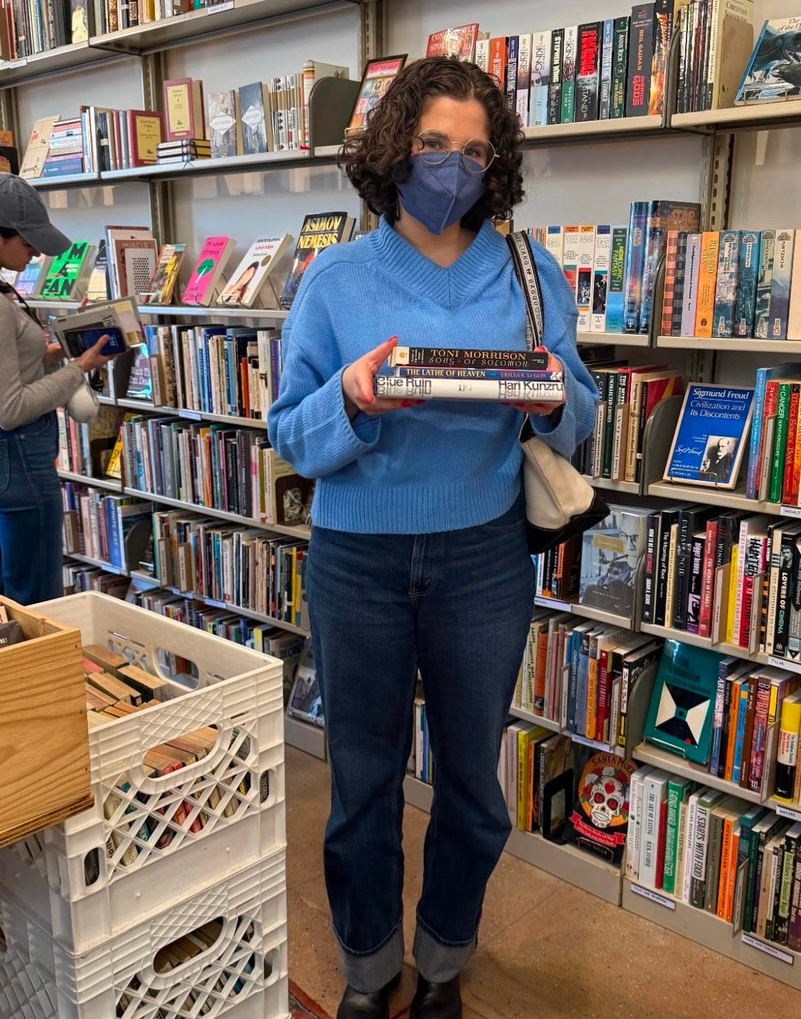 Sabrina holding a stack of books in a library
