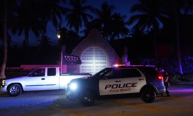 A supporter of former President Donald Trump drives past his Mar-a-Lago estate on Monday after the FBI carried out a search warrant at his Florida home.