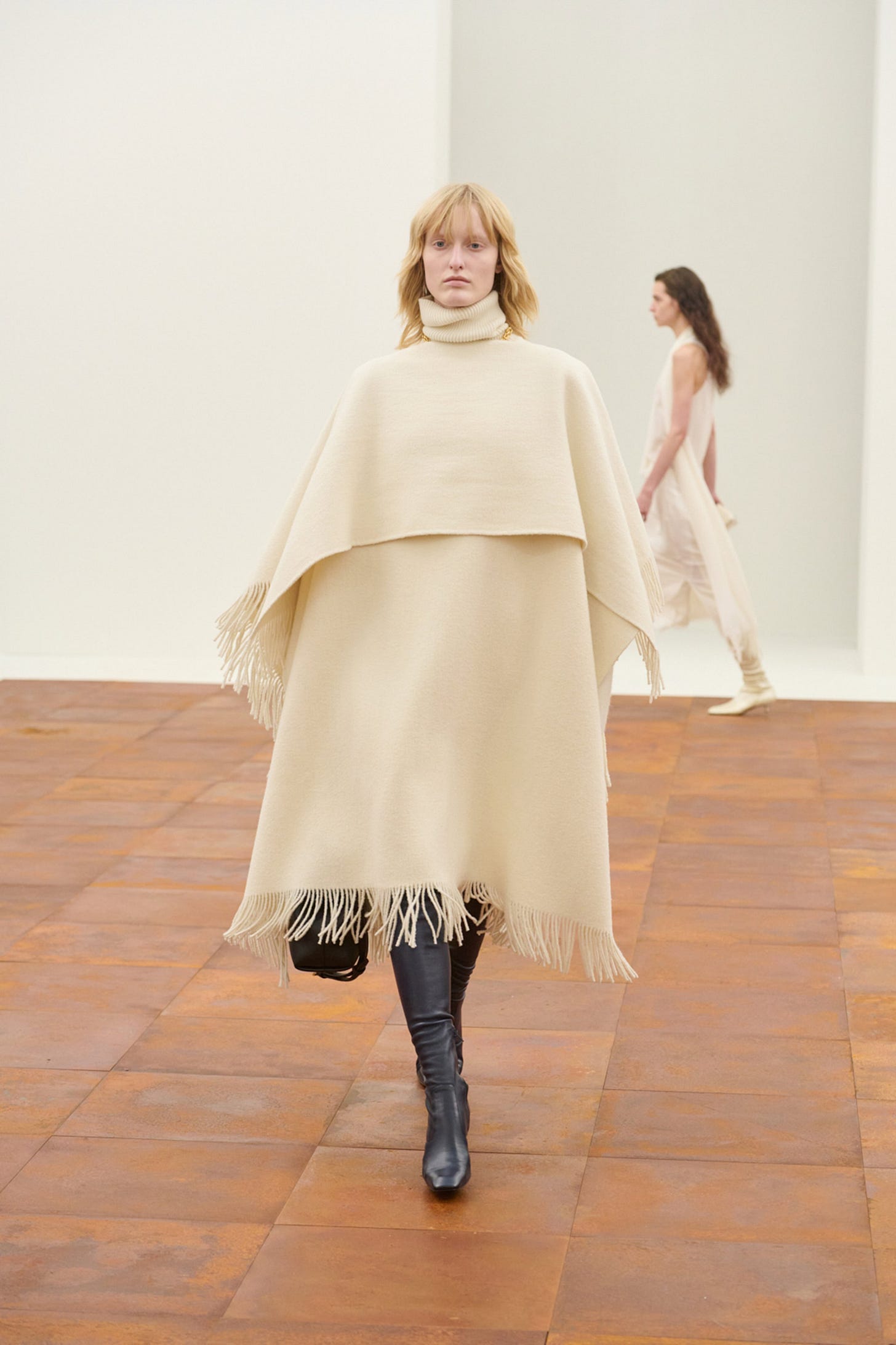 Image may contain Fashion Adult Person Floor Flooring Cape Clothing Footwear Shoe Cloak Poncho and Coat